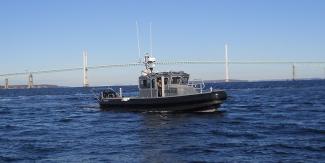 marine patrol boat on the water with bridge in the background
