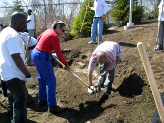 people raking and digging in dirt while others look on