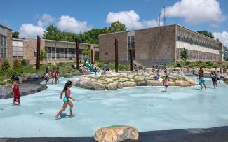 Children running and enjoying the spray park on a sunny day